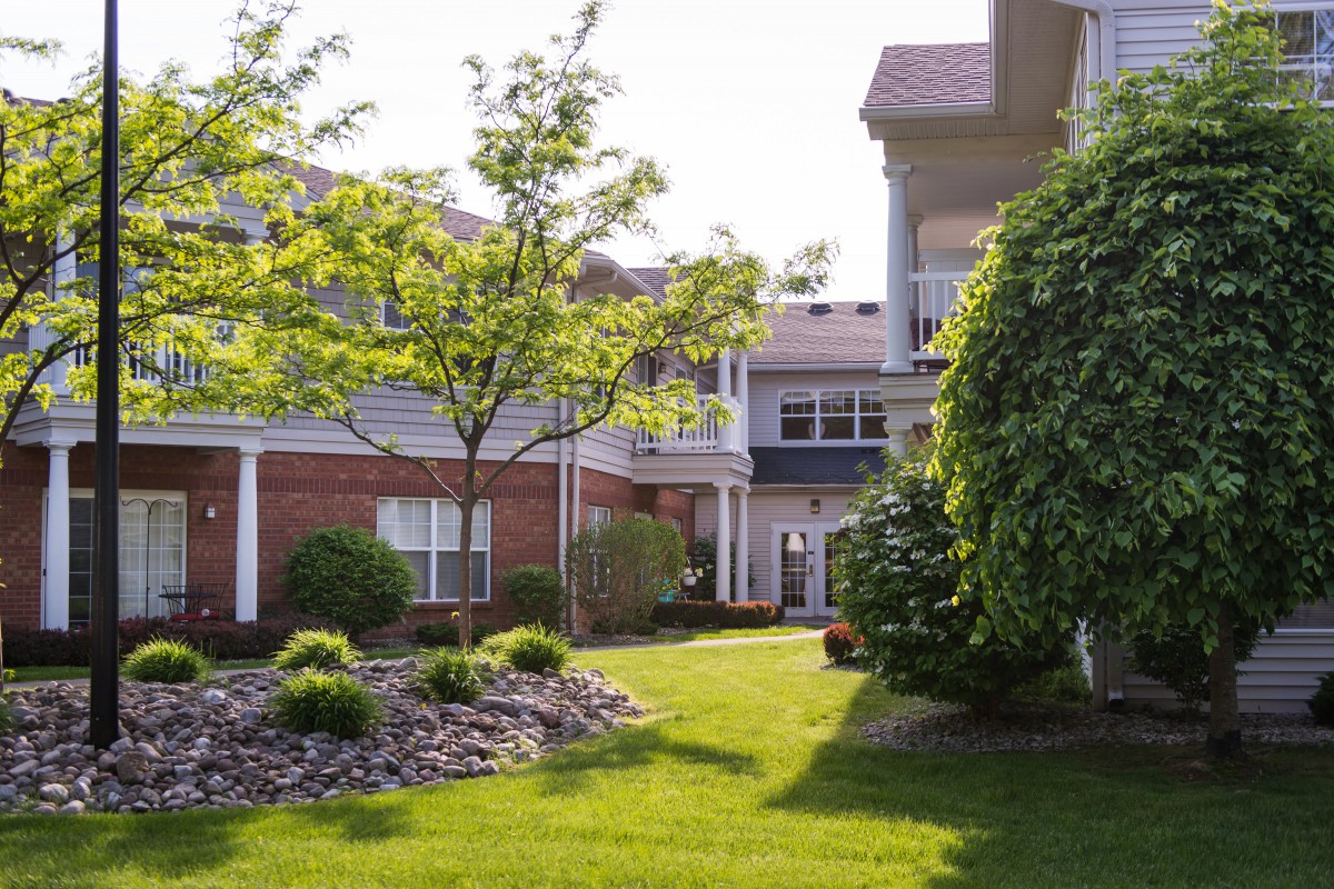 A landscaped courtyard with lush greenery and a building in the background.