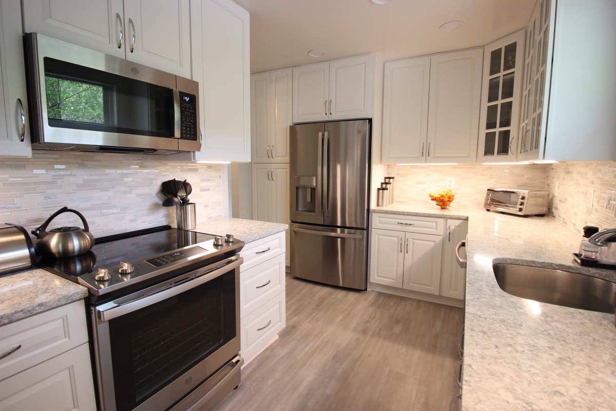 A modern kitchen with stainless steel appliances and white cabinets.