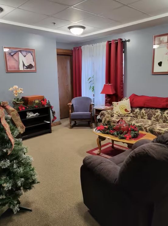 A cozy living room decorated for the holidays with a Christmas tree, festive decor, and comfortable seating.