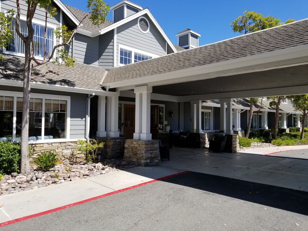 A large residential house with a covered entrance and driveway.