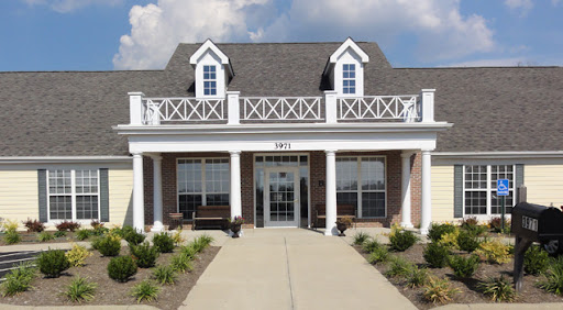 A charming two-story building with a welcoming front entrance and beautiful landscaping.