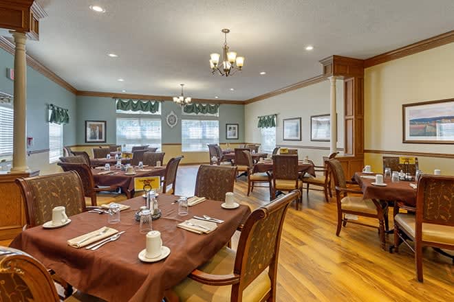 A well-arranged dining room with elegant table settings and a chandelier.