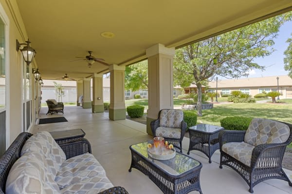 Spacious patio area with comfortable seating overlooking a lush garden.