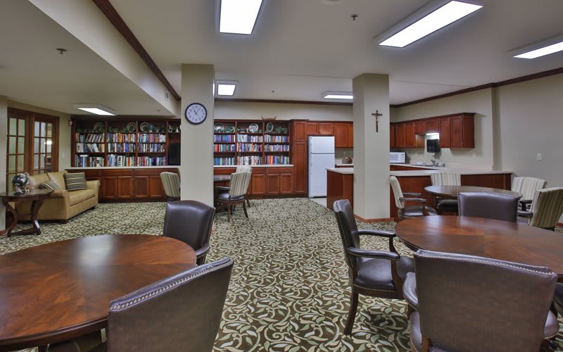 A cozy library with bookshelves, tables, and chairs for reading and studying.