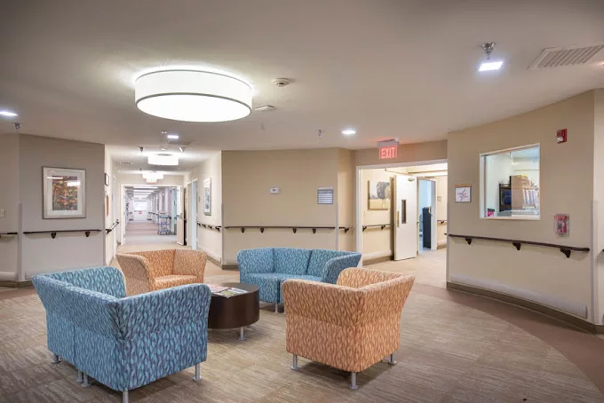 A modern waiting area with colorful seating and a well-lit corridor.