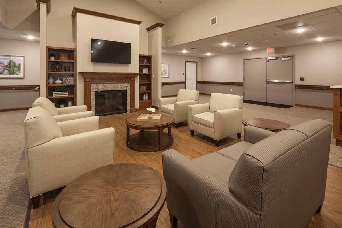 A modern lobby with comfortable seating, a fireplace, and a wall-mounted television.