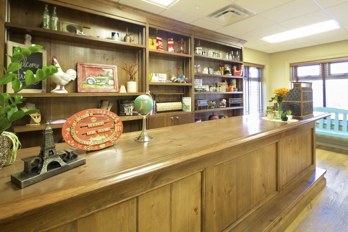 A reception area with a wooden desk and shelves filled with various decorations.