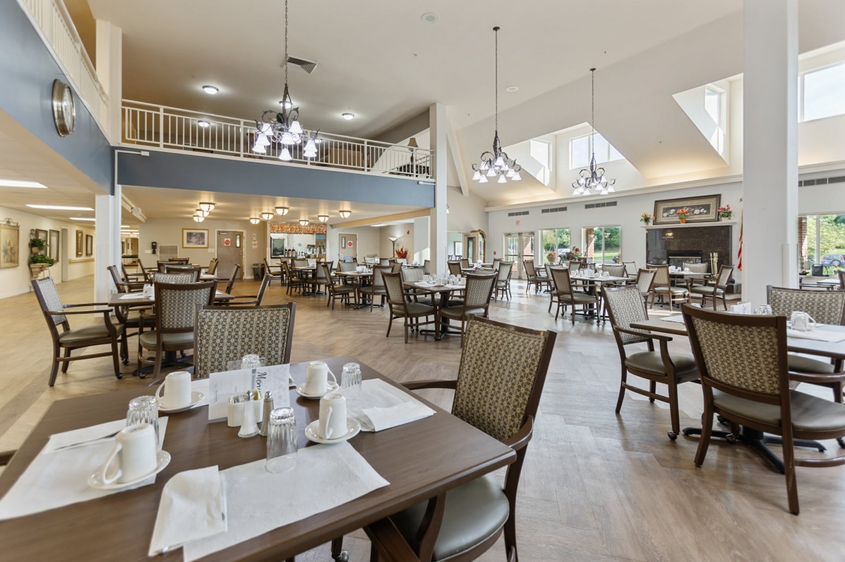 A spacious dining area with elegant lighting and neatly arranged tables.