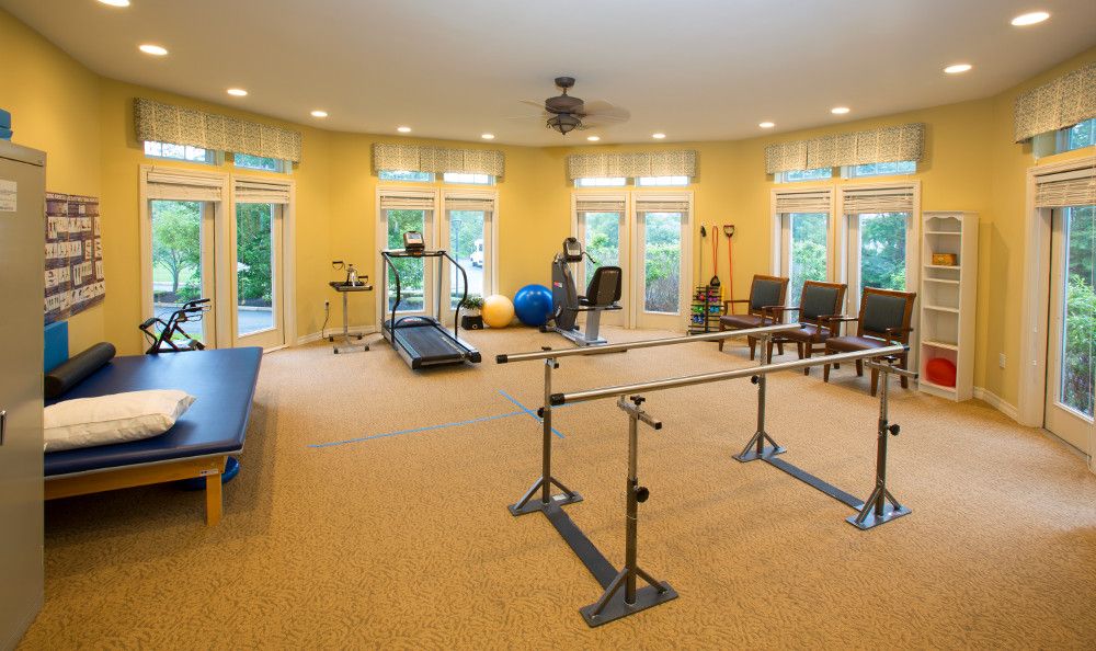 A well-equipped rehabilitation room with exercise equipment and therapy tools.