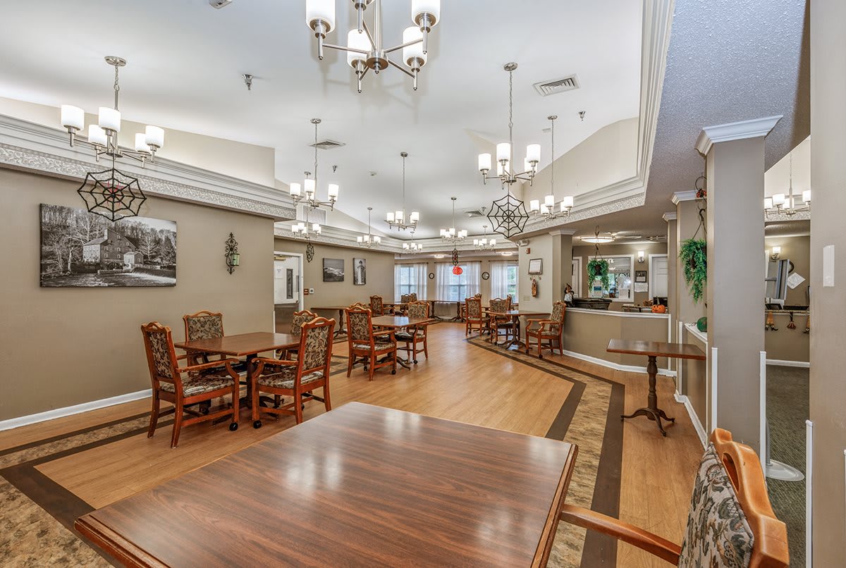 A spacious and elegantly decorated dining area with wooden floors and chandeliers.