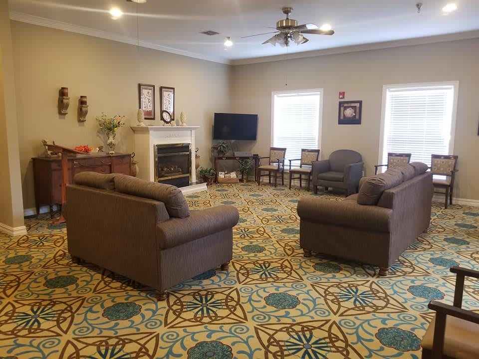 A cozy living room with sofas, armchairs, a television, and a fireplace.