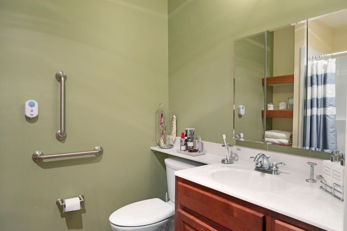 A neatly organized bathroom with a sink, mirror, and toilet.
