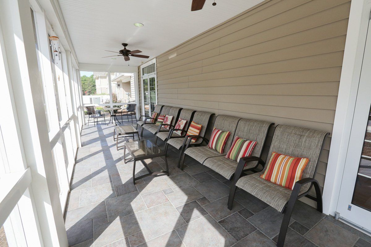 A bright and airy porch with comfortable seating and colorful cushions.