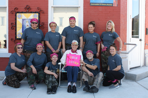 A supportive team gathered for a community event, showcasing unity in style with their pink headbands.