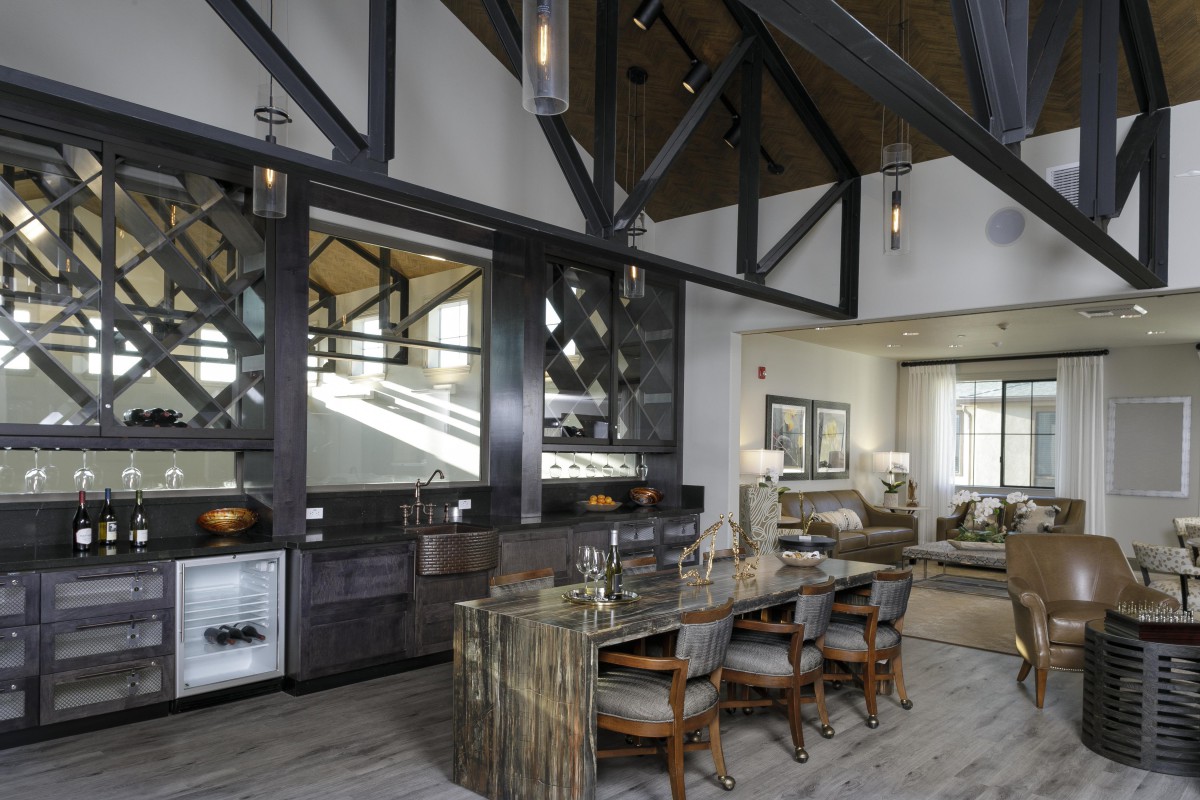 A modern kitchen and dining area featuring high ceilings with exposed beams and contemporary furnishings.