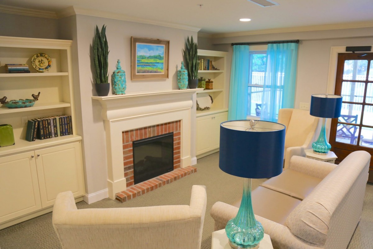A cozy living room with a fireplace, blue accents, and comfortable seating.