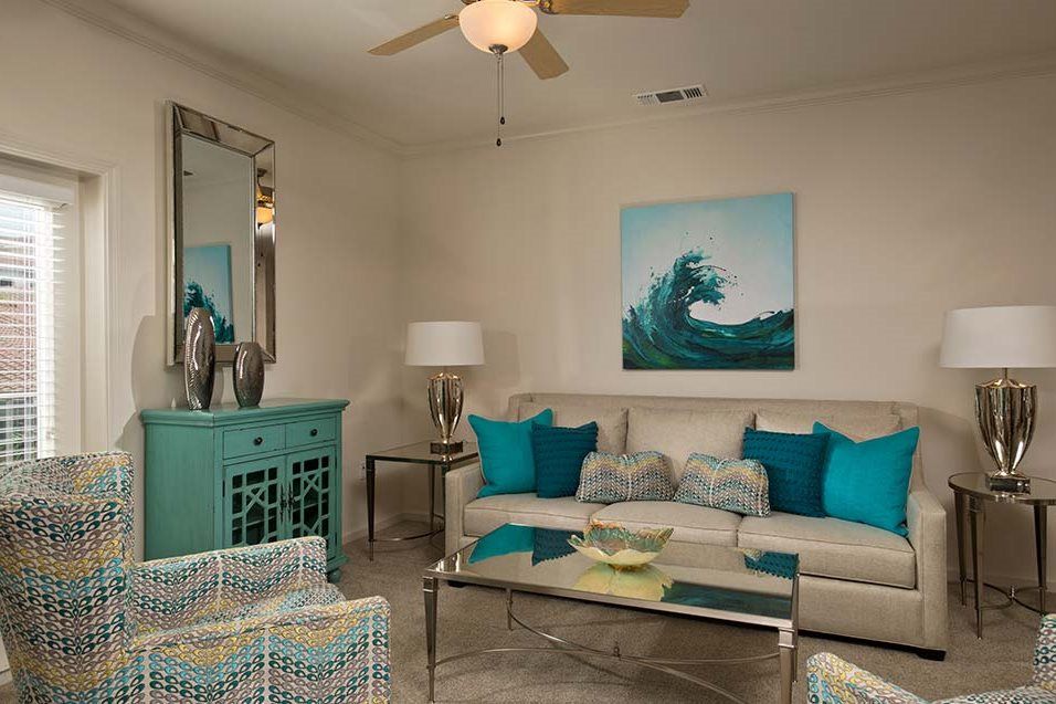 A modern living room with a beach-themed decor featuring turquoise accents and neutral tones.