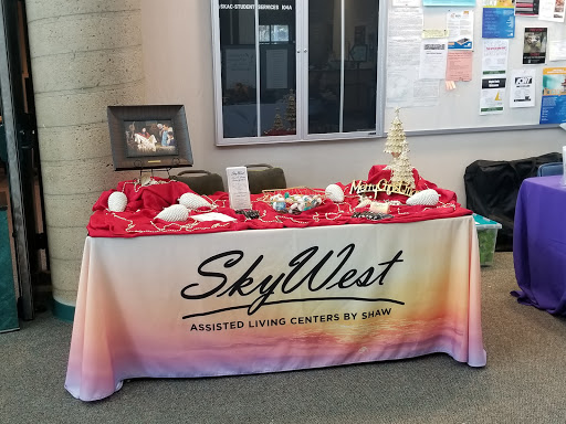 A promotional table for SkyWest featuring marketing materials and a vibrant red tablecloth.