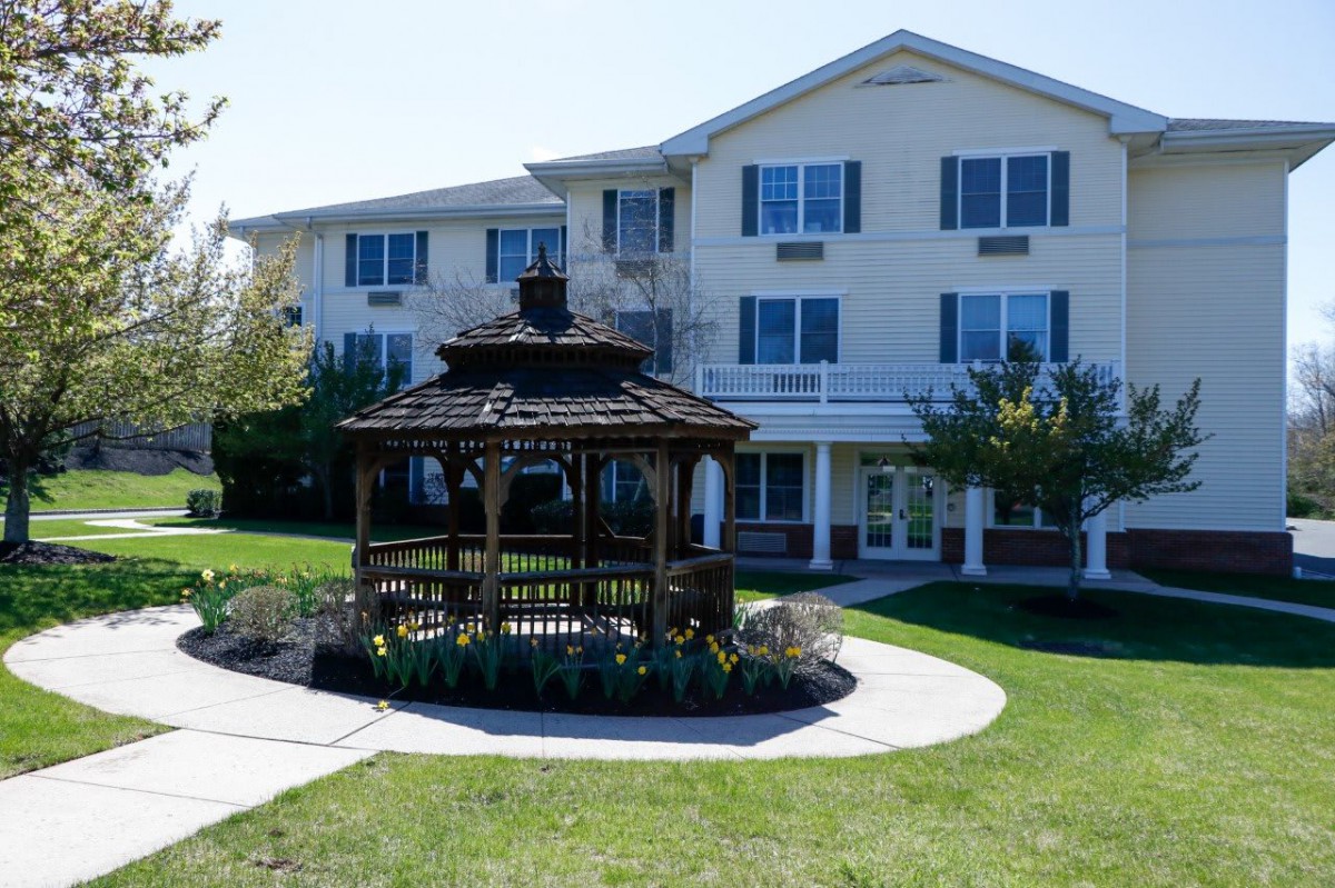 A residential building with a charming gazebo in the landscaped garden.