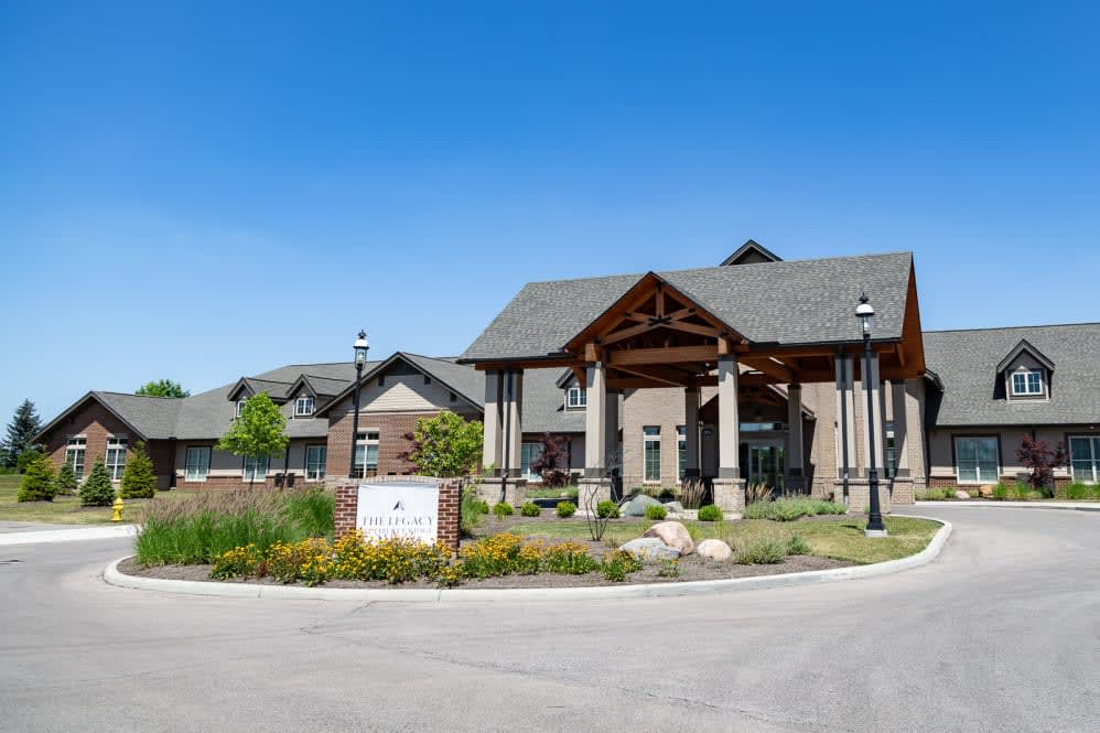 A residential building with well-maintained landscaping and a clear blue sky.
