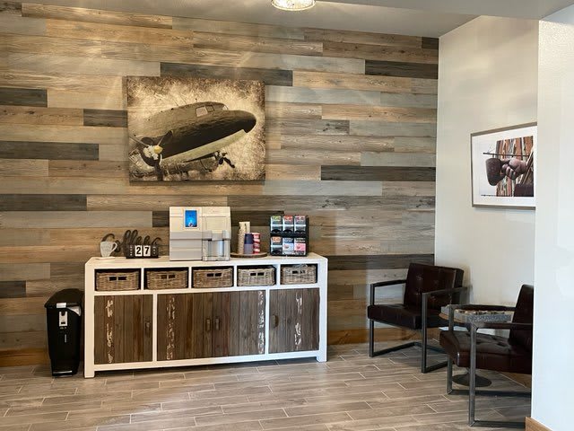A modern waiting room with a coffee station and wall art.