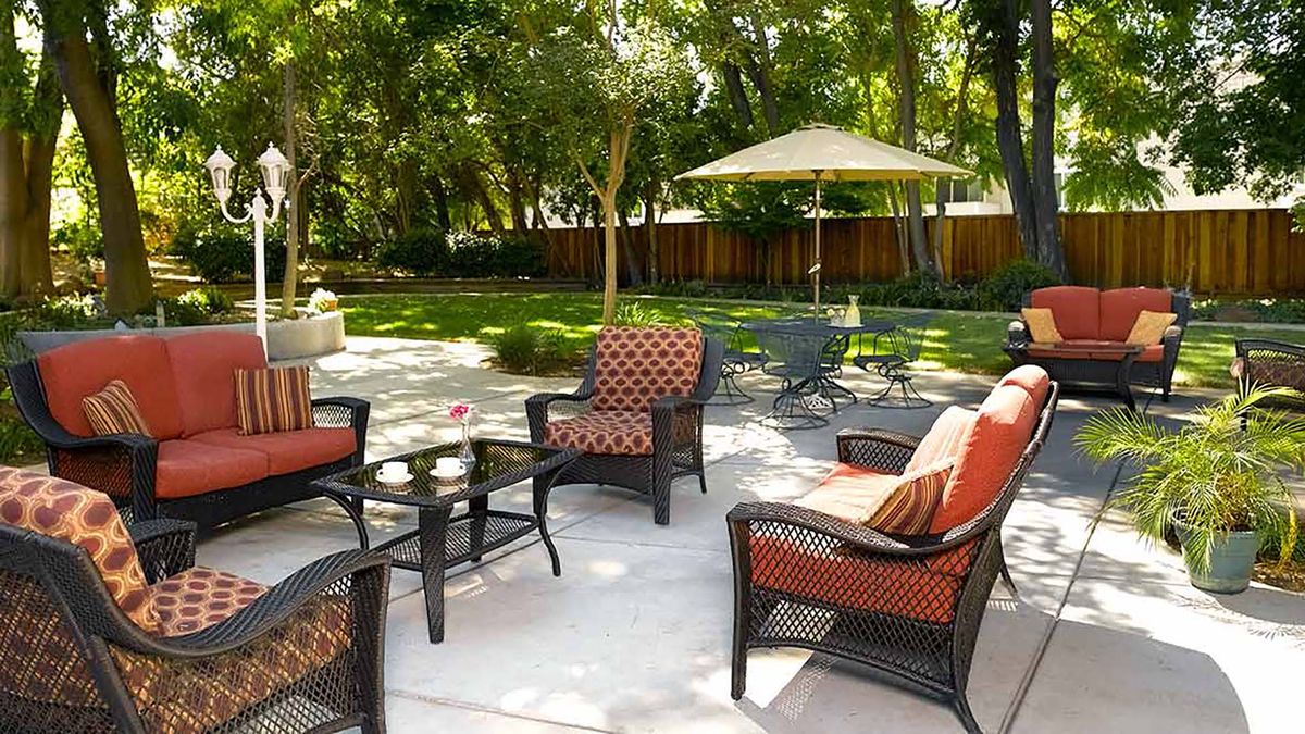 A cozy patio setup with wicker furniture and a garden view.