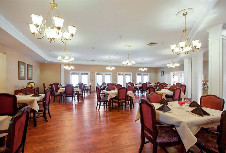 An elegant dining room with neatly arranged tables and chandeliers.