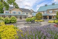 A scenic view of a building with a landscaped garden and flowers in the courtyard.