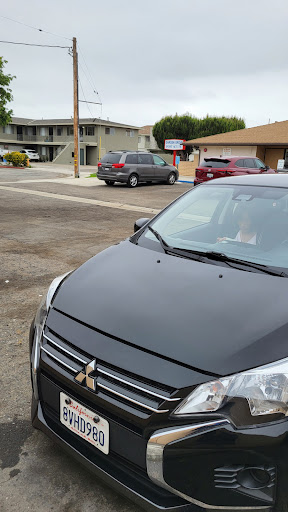 A Mitsubishi car parked in an urban area near several buildings.