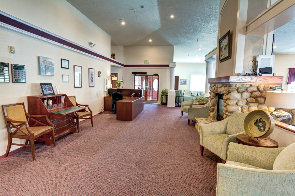 A spacious lobby with seating, a piano, and a fireplace.