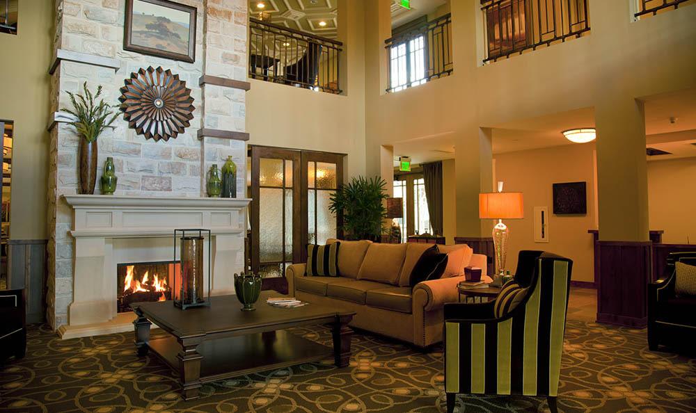 A cozy living room with a fireplace, comfortable seating, and elegant decor.