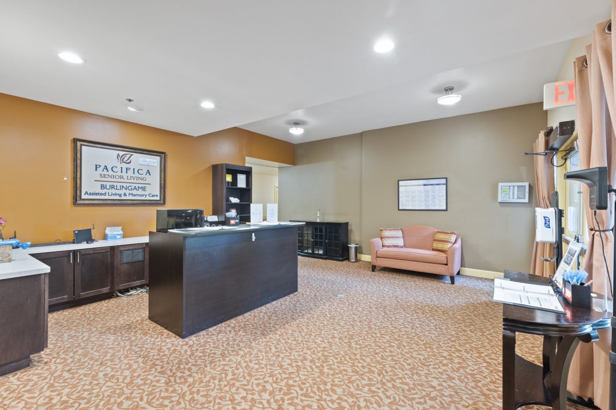 A spacious office reception area with a desk, seating, and decor.