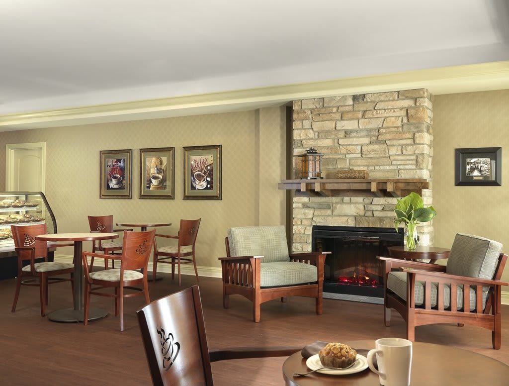 A cozy lounge area with a stone fireplace and comfortable seating.