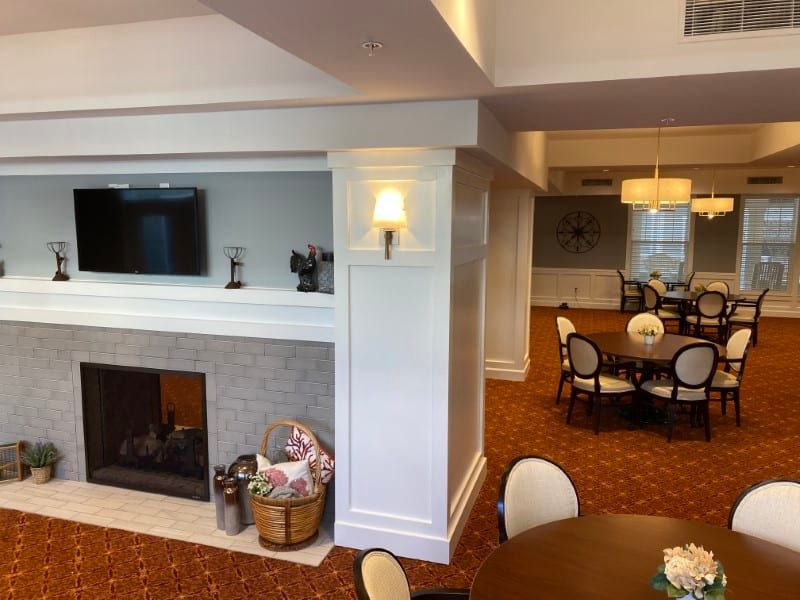 A cozy living room area featuring a fireplace and adjacent dining space, decorated with neutral tones.