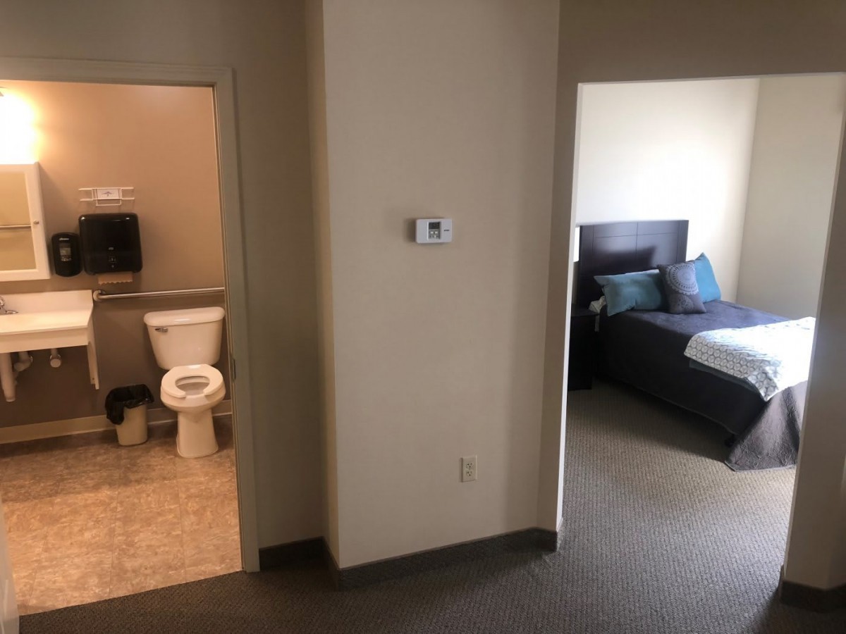 A view of an apartment with a bathroom and a bedroom.