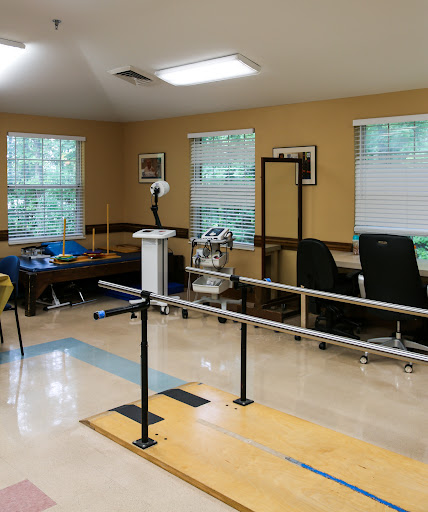 A well-equipped physical therapy room featuring balancing bars and various rehabilitation tools.