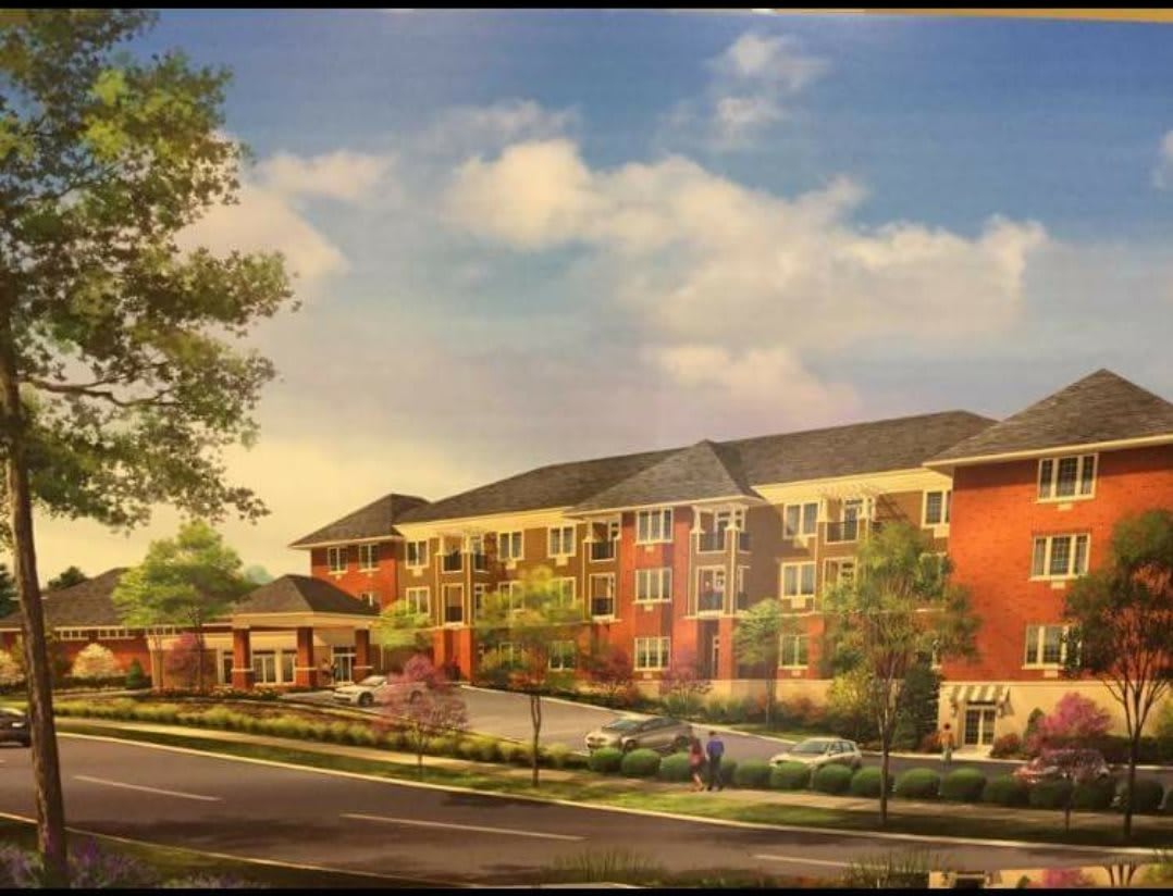 An illustration of a suburban residential building with multiple floors and landscaped surroundings.