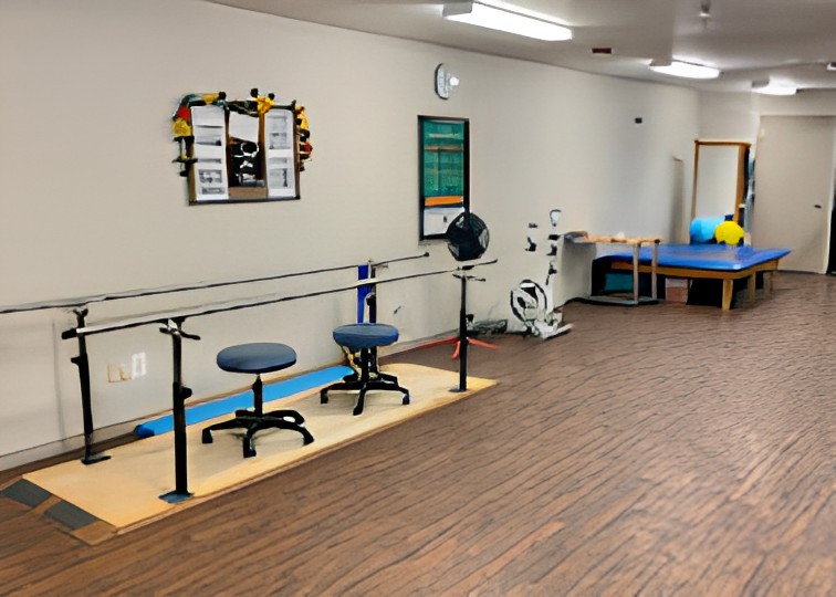 A physical therapy room equipped with parallel bars and exercise equipment.