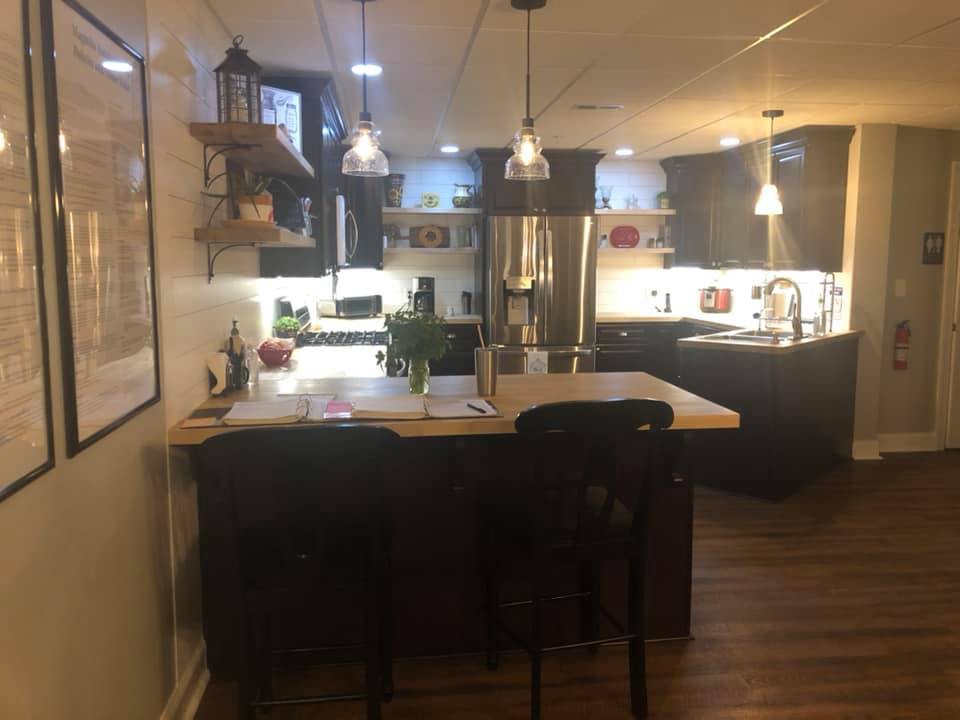 A cozy kitchen with a central island and pendant lights.
