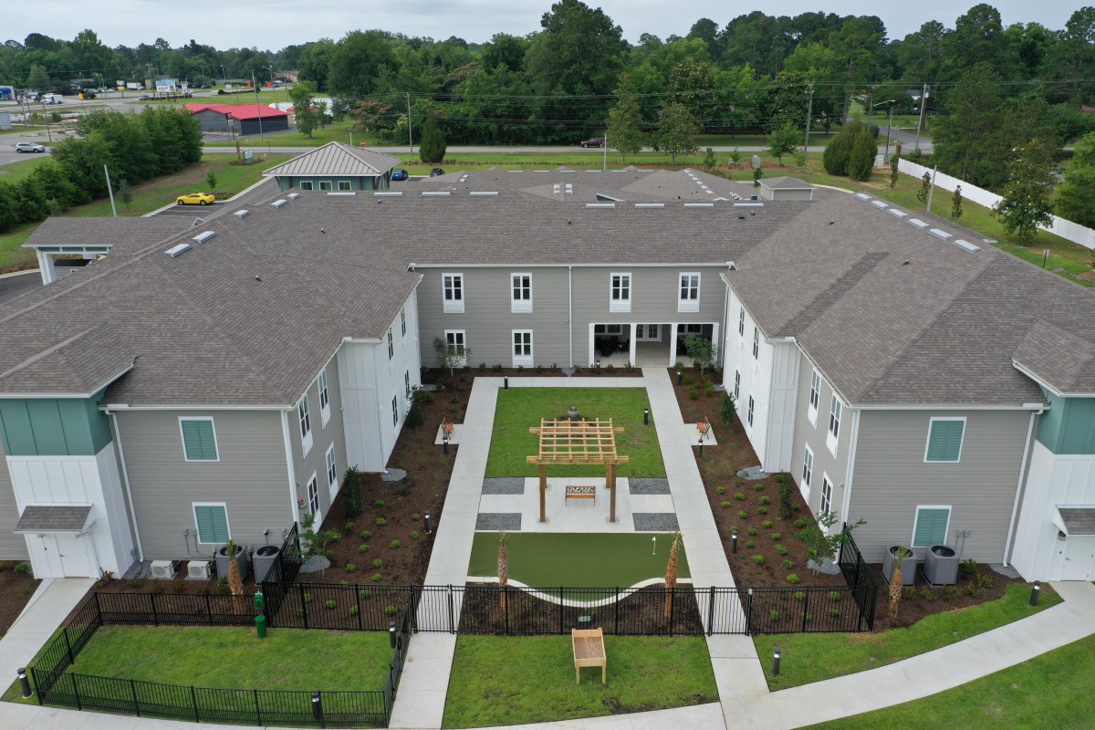 A modern residential building with a landscaped courtyard, captured from an aerial perspective.