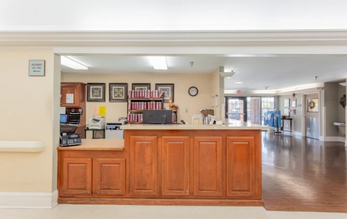 A reception area with a wooden counter and office supplies in the background.