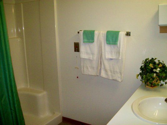 A clean bathroom with a shower and neatly hung towels.