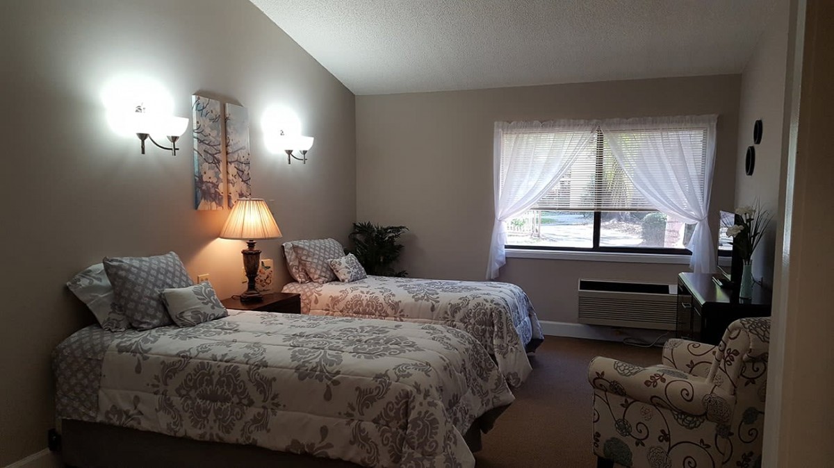 A cozy bedroom with twin beds and a softly lit ambiance.