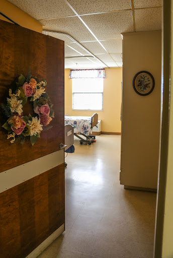 A view through an open door into a hospital room, adorned with flowers for a touch of warmth.