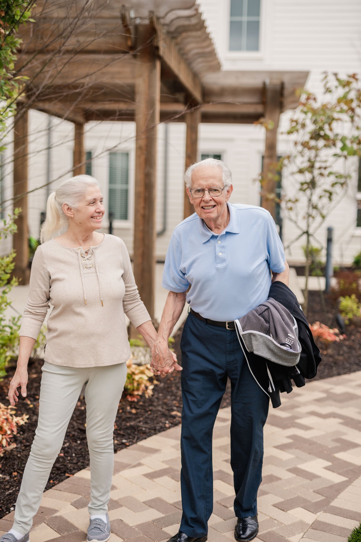 An elderly couple enjoying a walk together in the park.
