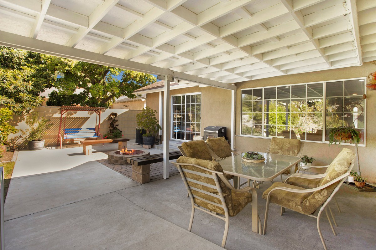 A spacious outdoor patio with a glass table and chairs, perfect for relaxation.