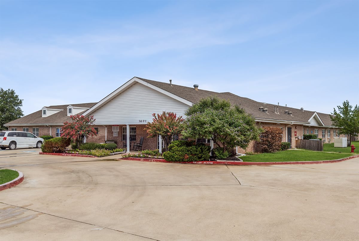 A suburban residential building with a landscaped front yard.