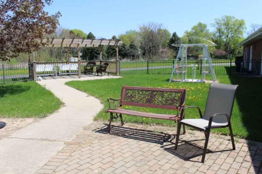 A peaceful outdoor area with a bench, pathway, and swing set.