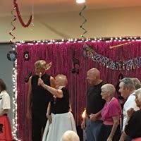 A group of seniors enjoying a dance party with festive decorations.