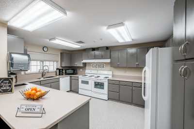 A modern kitchen with gray cabinets and various appliances.